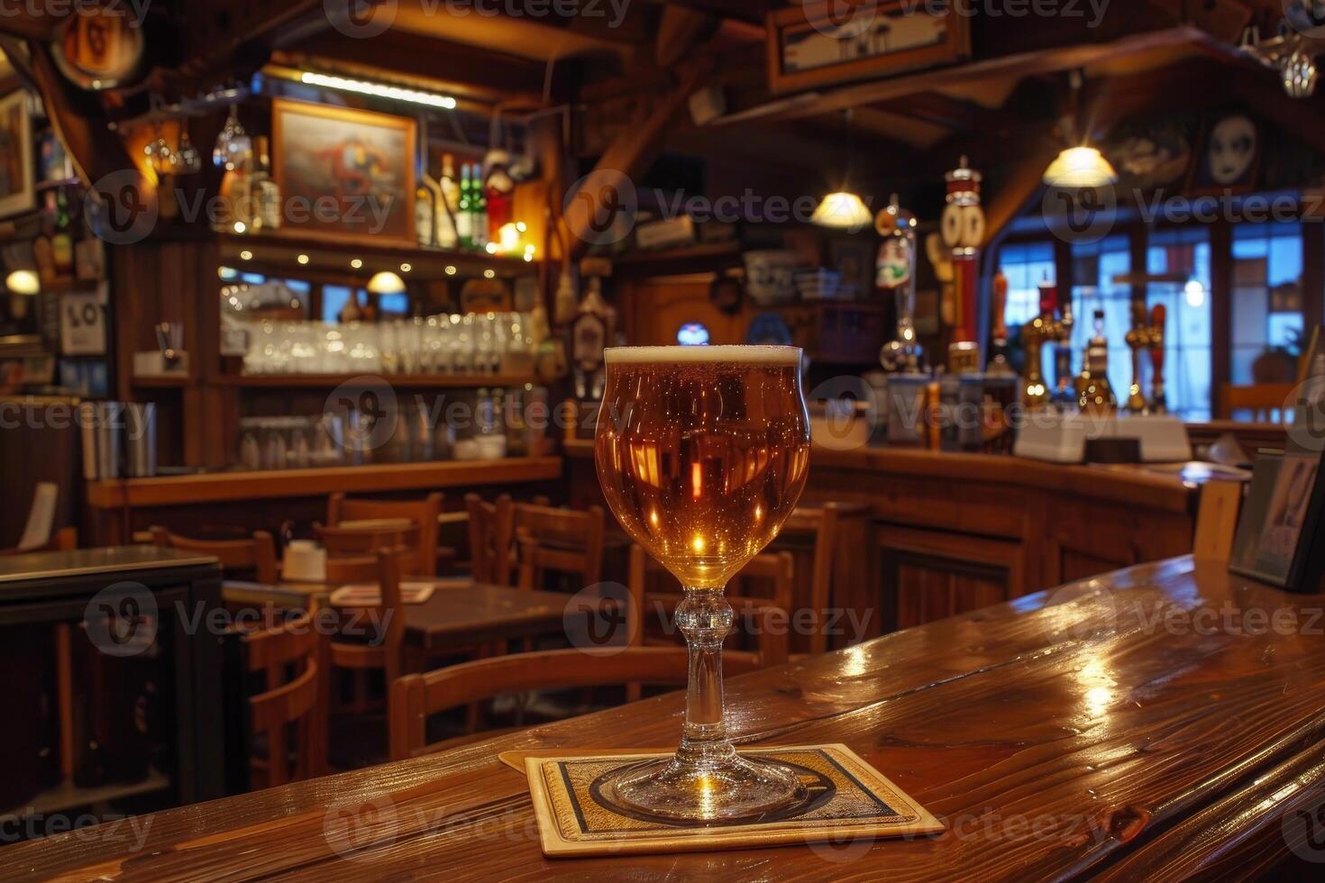 Glass of cold beer standing on countertop in empty bar at night photo
