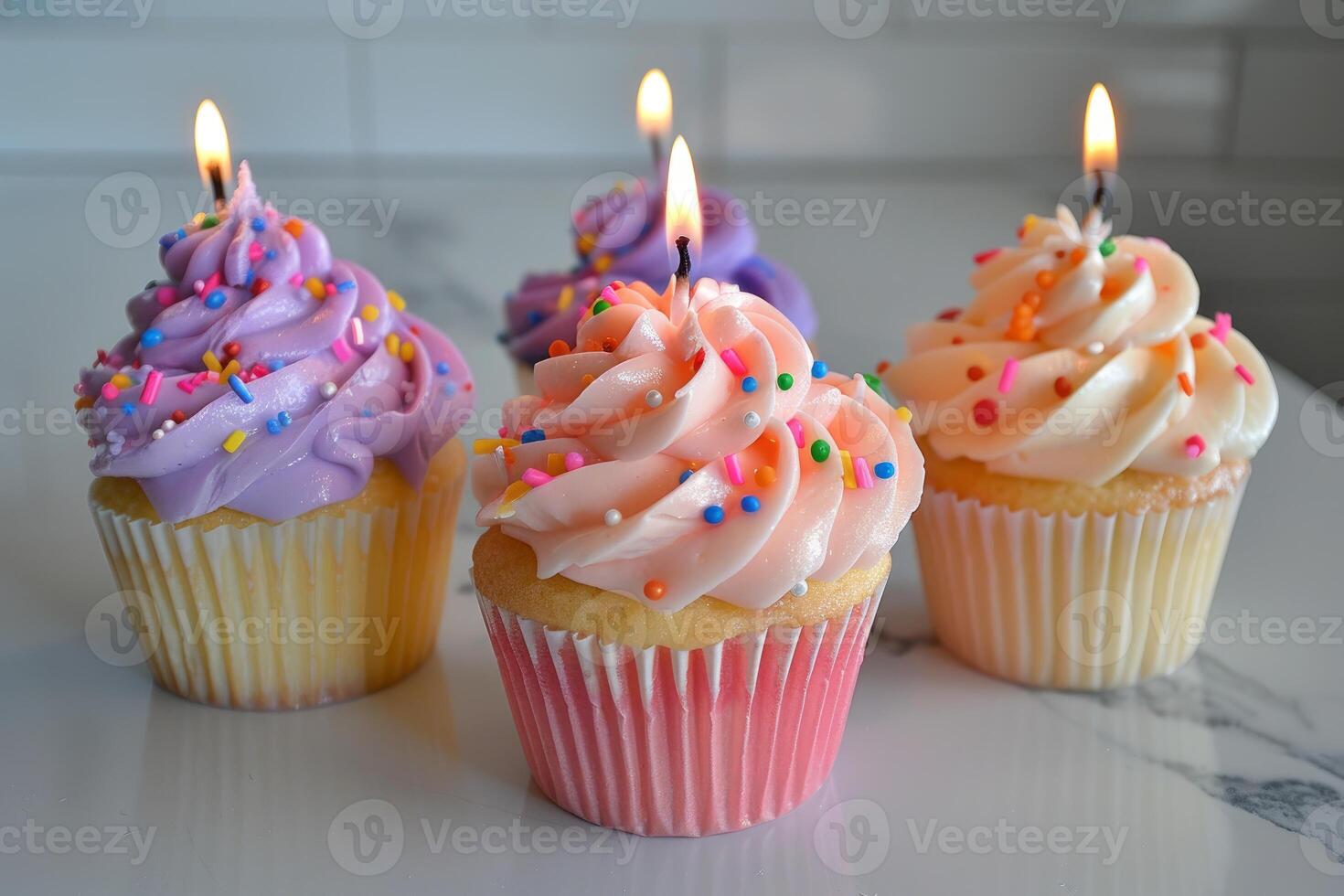 Delicious birthday cupcakes with lit candles and sprinkles on white background photo