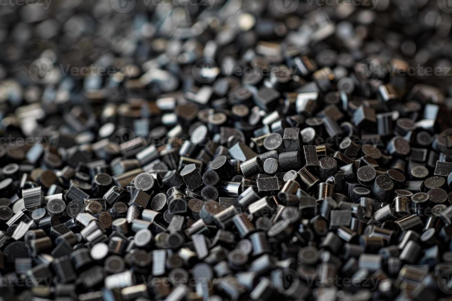 Black plastic polymer granules forming a heap for further processing photo