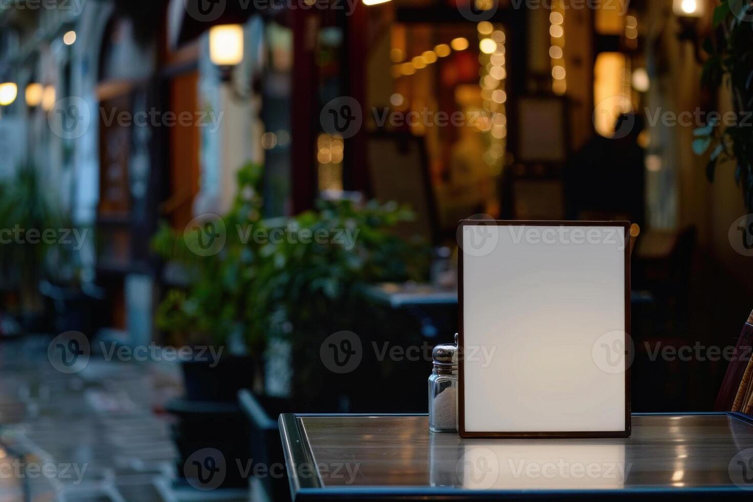 Empty menu displaying on a table of a restaurant at night photo