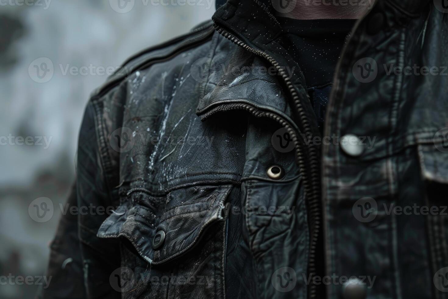 Construction worker wearing black denim jacket covered in white paint splatter photo
