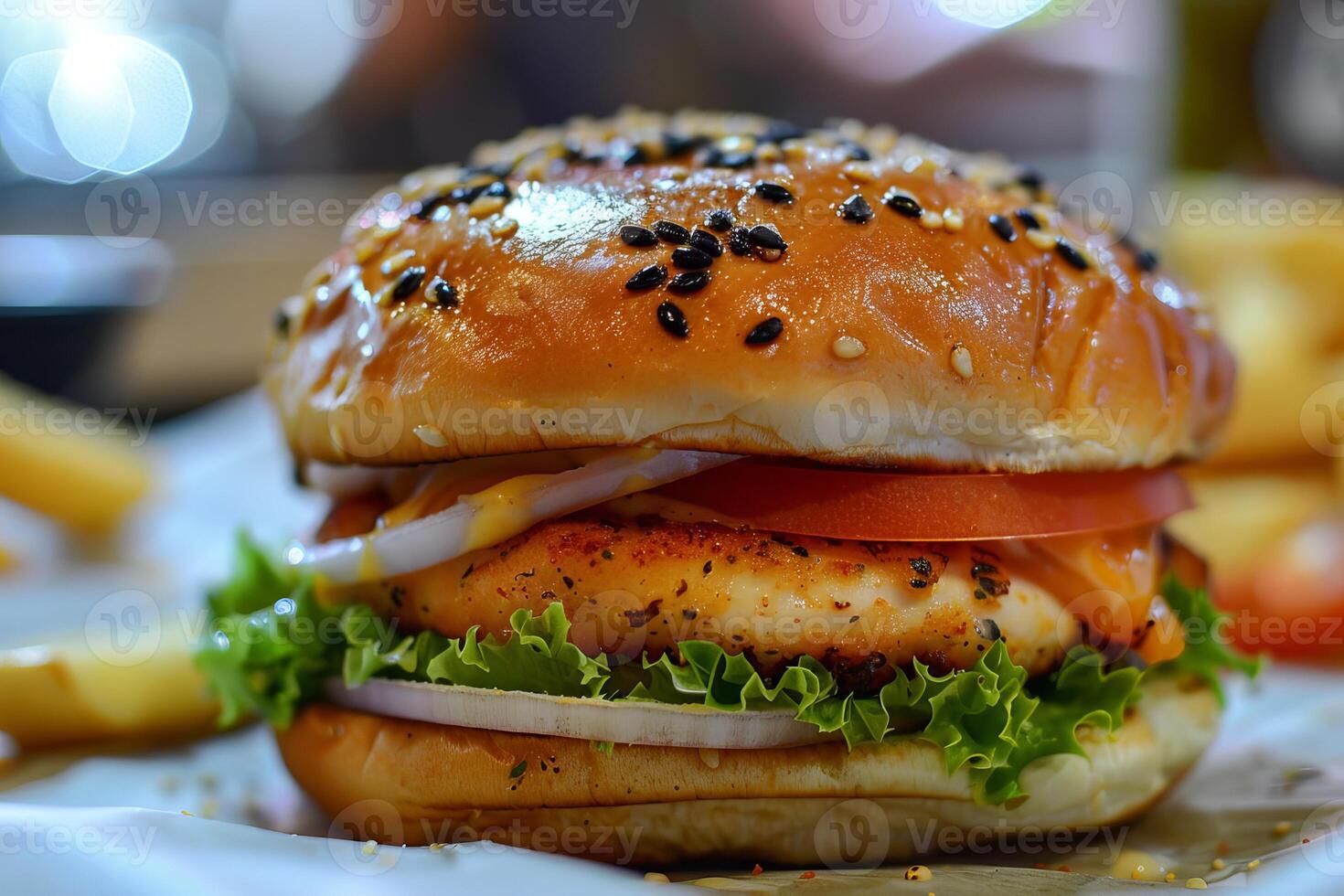 Delicious chicken burger with lettuce and tomato on sesame seed bun is waiting to be eaten photo