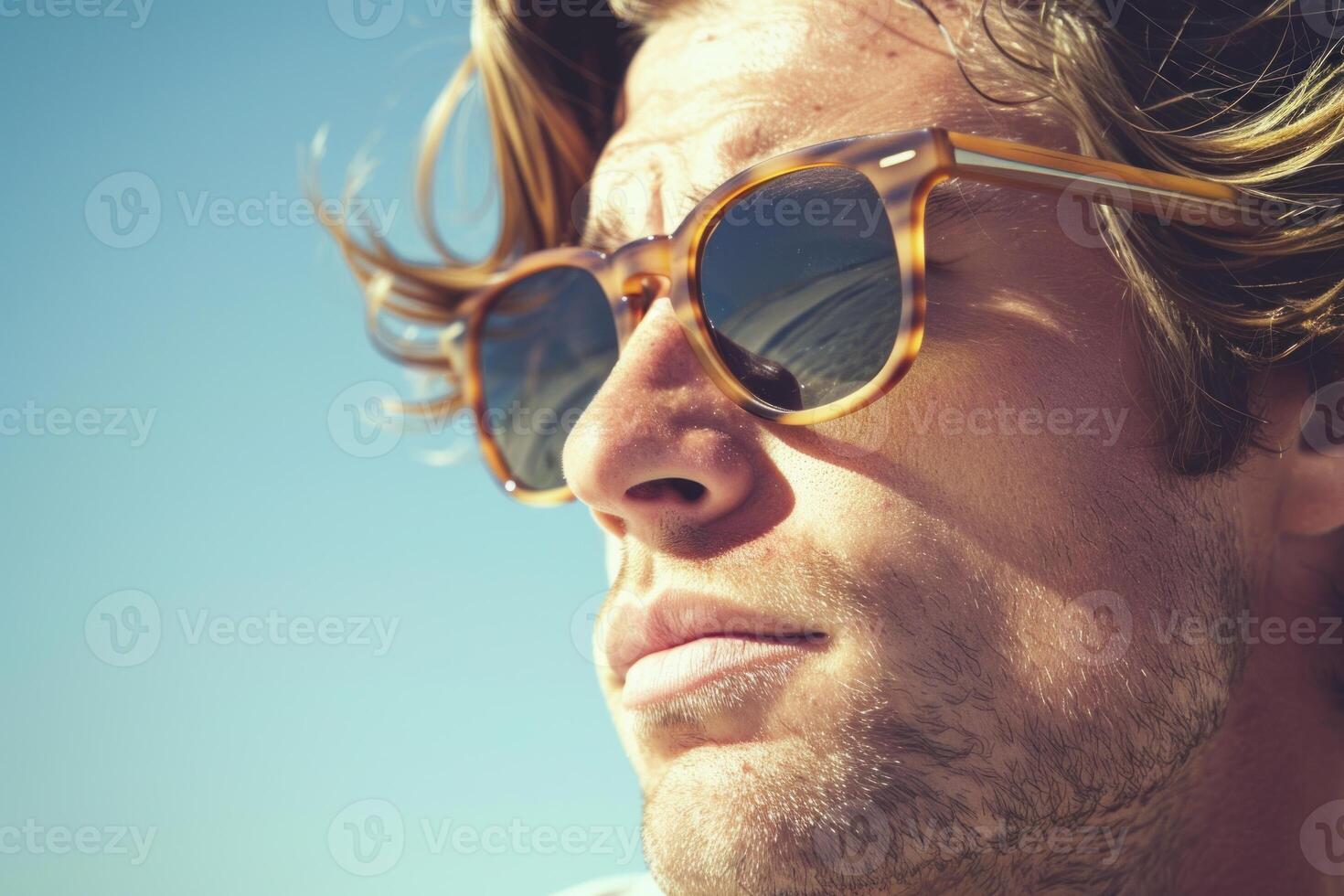 Young man with sunglasses is posing under the sun photo