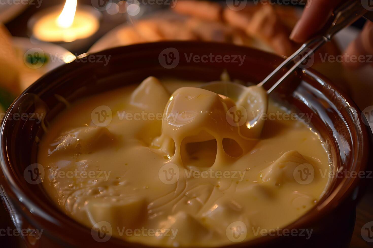 Dipping bread in melted cheese fondue in a communal pot photo