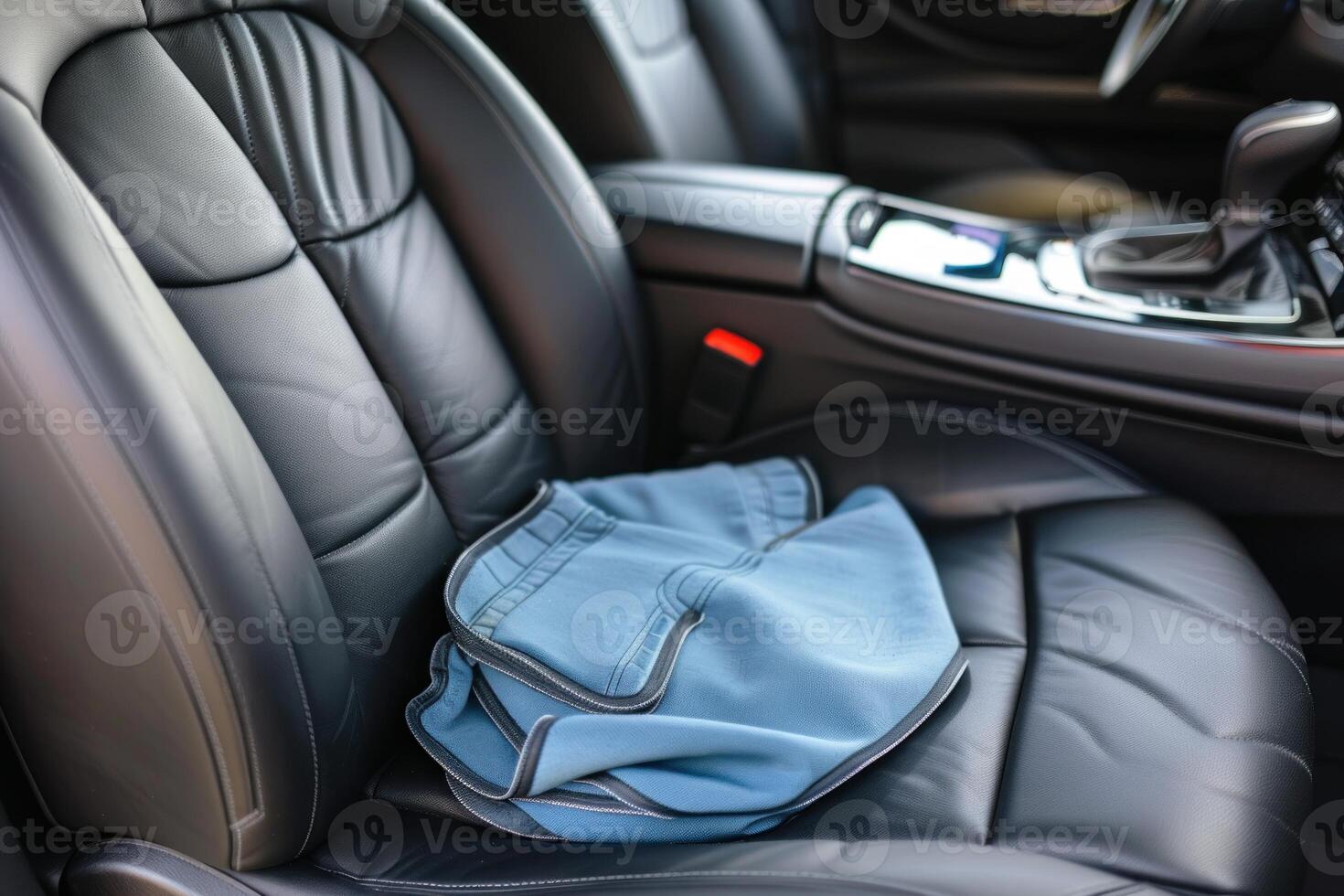 Blue towel protecting leather car seat from wet clothes photo