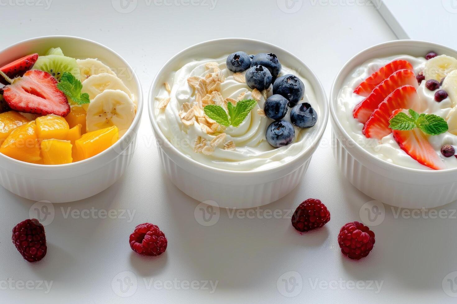 Three white bowls filled with yogurt, fresh fruits, and oats topped with mint photo