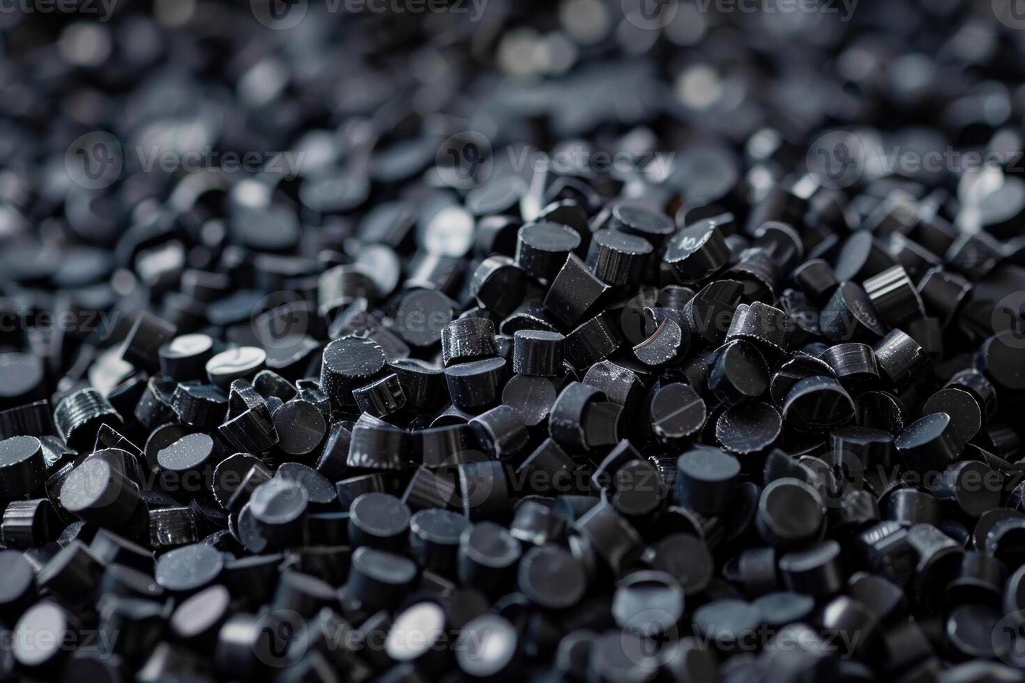 Black plastic polymer granules forming a pile for further processing photo