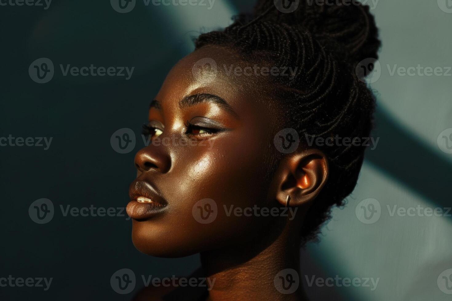 Portrait of a young black woman with braids and golden skin posing in the sunlight photo