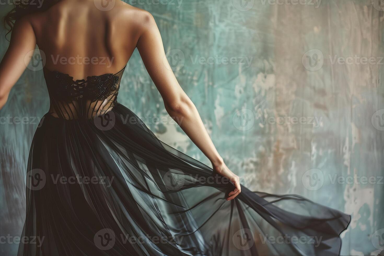 Woman wearing beautiful long elegant black dress posing in studio photo