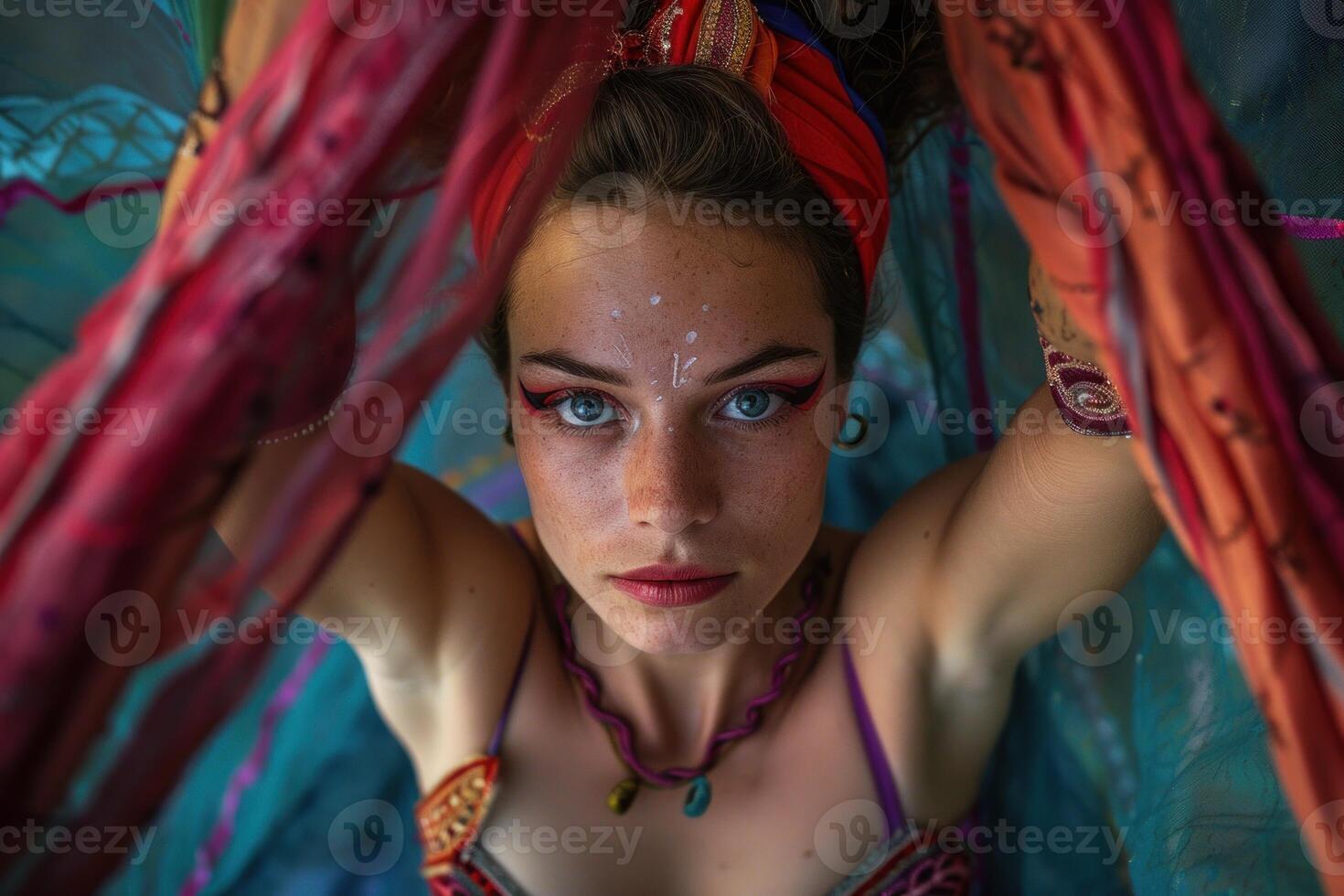 Young woman with blue eyes and freckles posing holding a colorful scarf photo