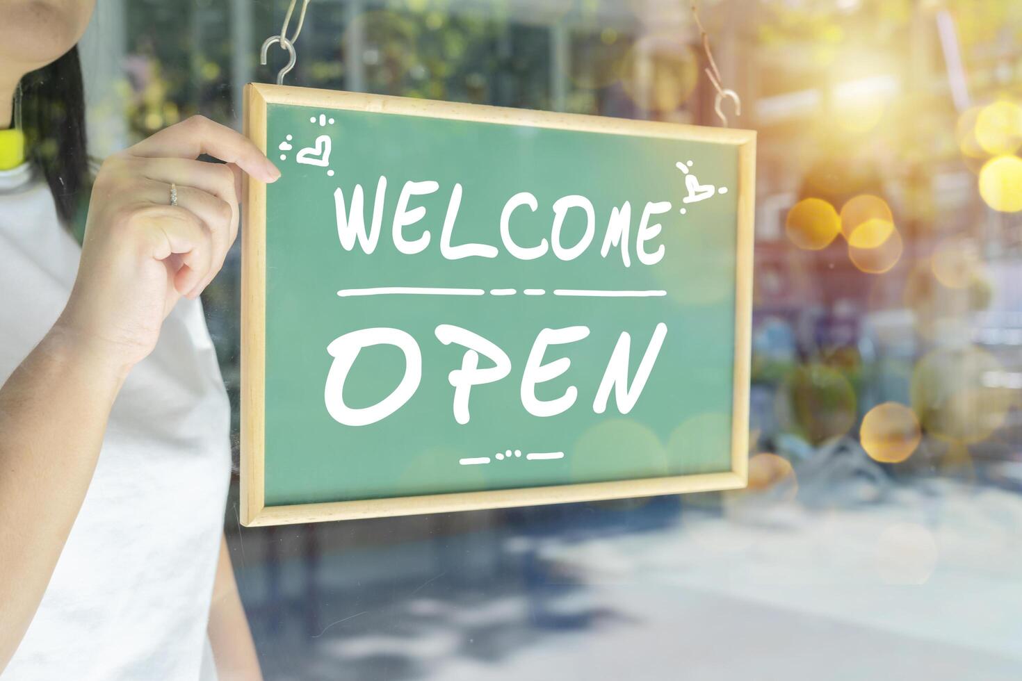 Asian restaurant owners are hanging a blackboard with the word welcome open to open the shop photo