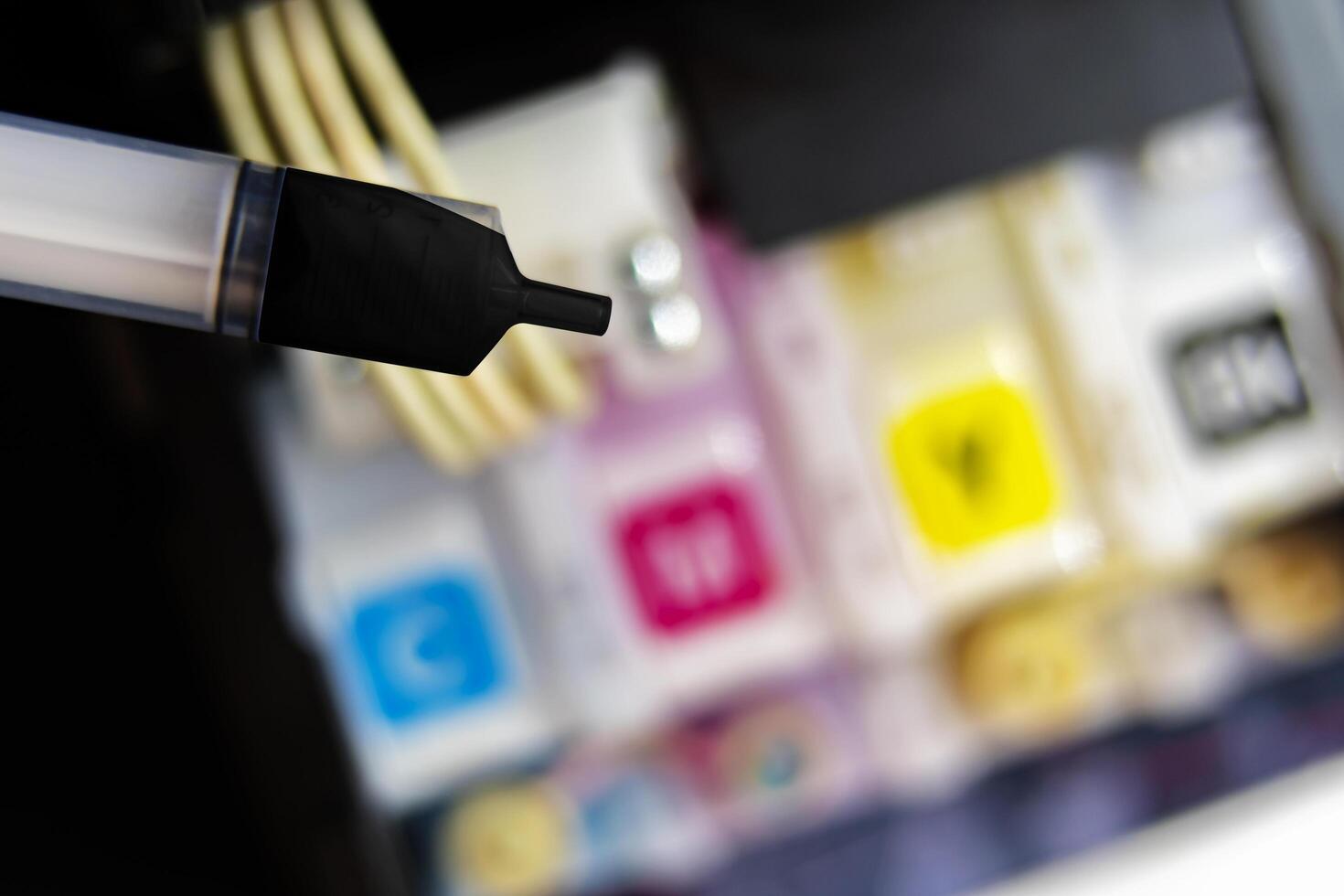 Closeup Refilling ink into a black ink tank printer at office photo