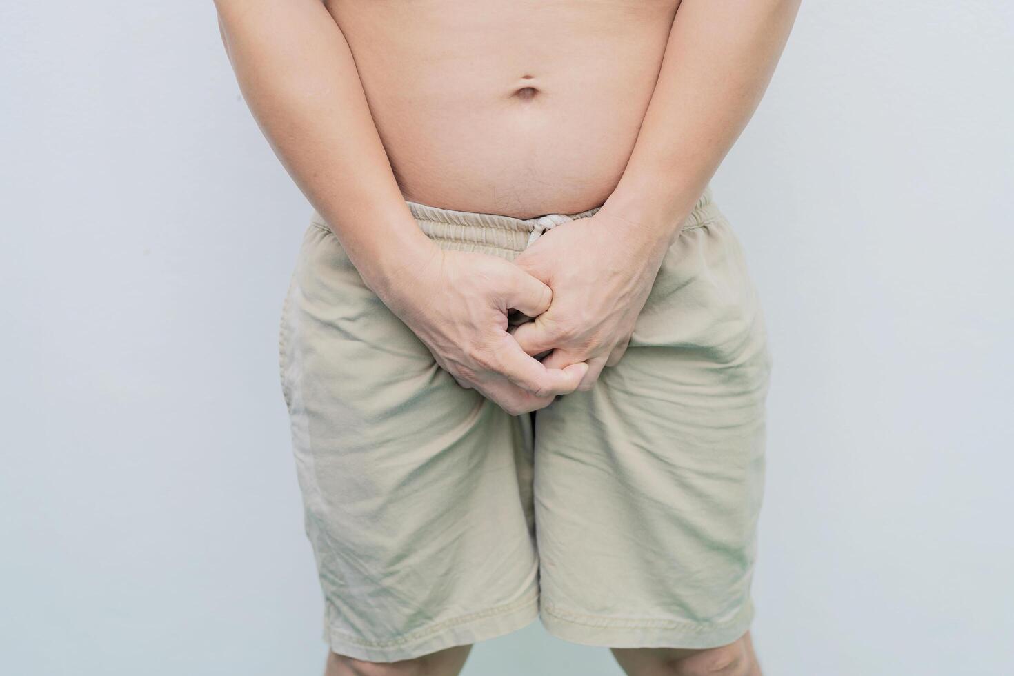 Close up of a man with hands holding his crotch photo