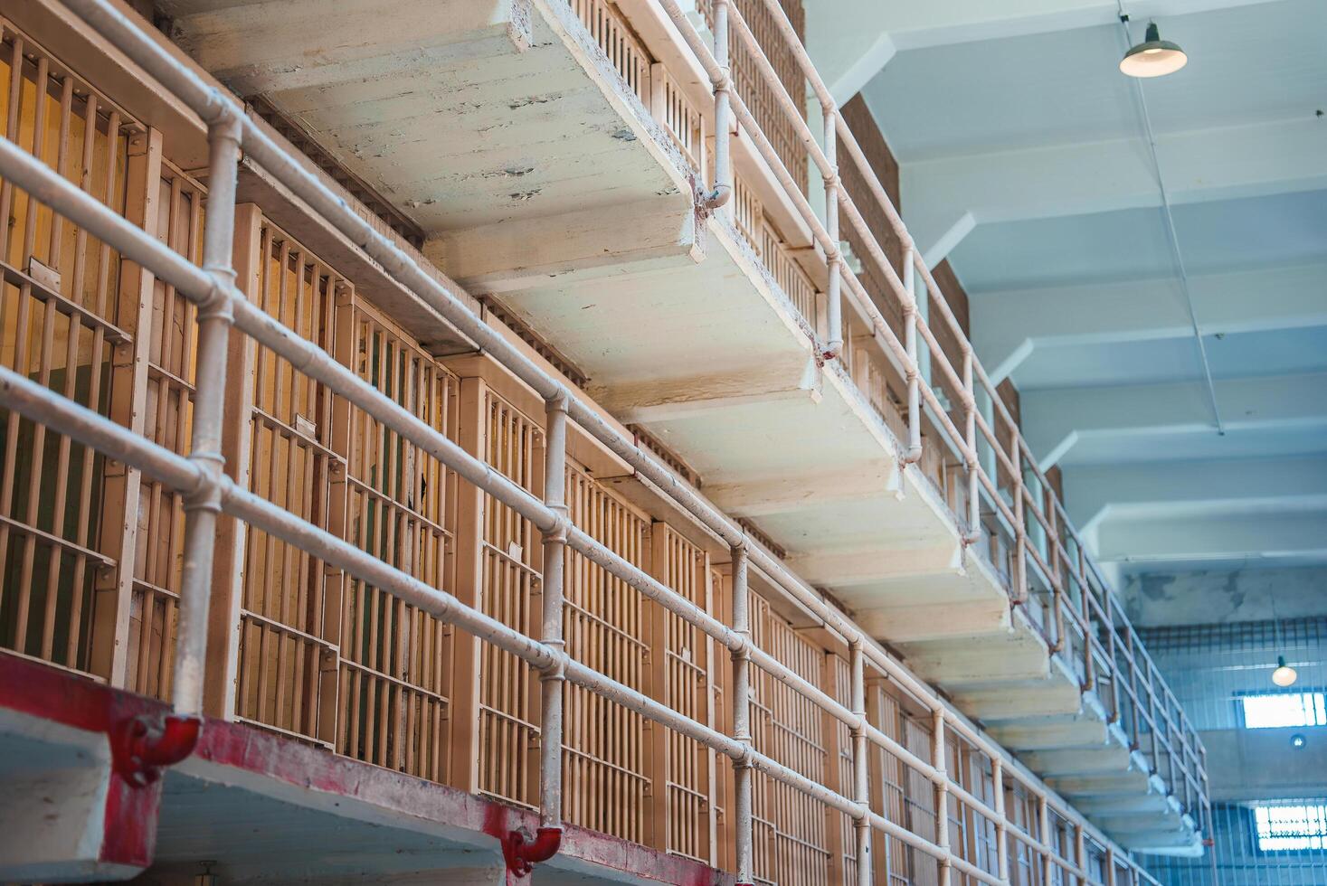 Explore the eerie interior of Alcatraz prison in San Francisco, USA. Walk down the corridor lined with cells, each with a barred door and peeling paint. photo