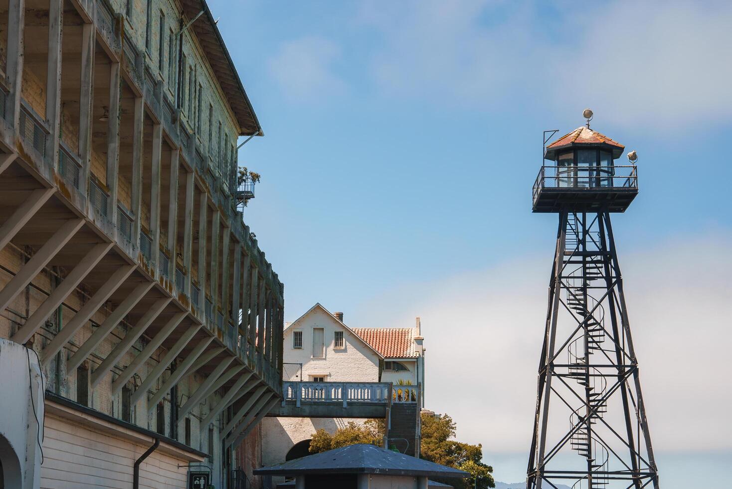 Historic scene at Alcatraz prison in San Francisco, USA. Shows old prison building, watchtower for surveillance, administrative building. Good weather. photo