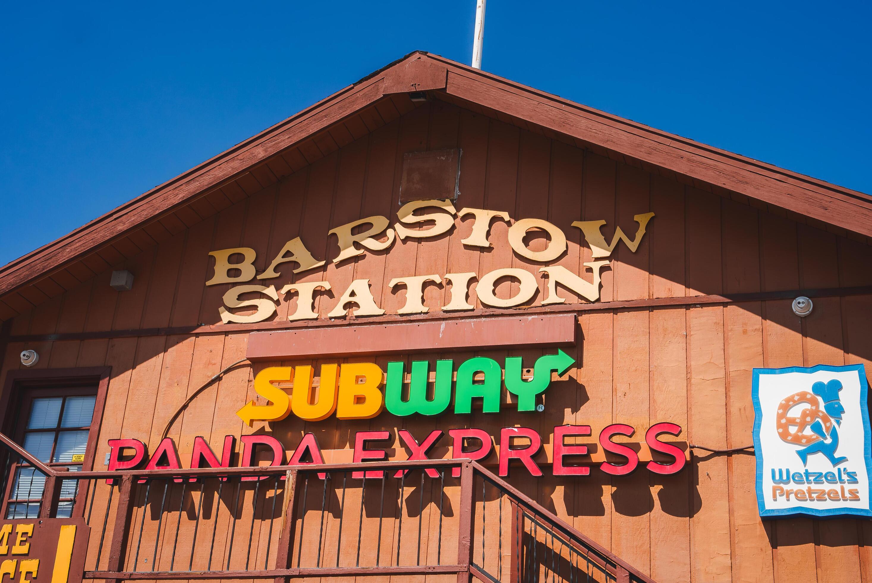 Rustic Building with BARSTOW STATION Sign, Fast Food Logos, Blue Sky