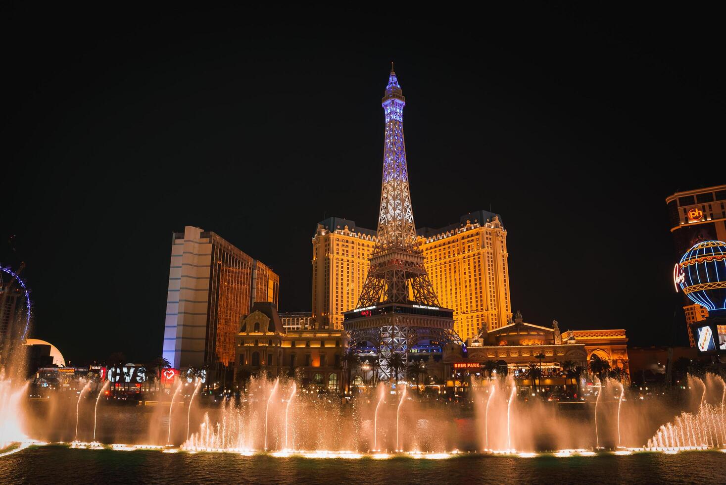 Las Vegas Strip Night Scene with Eiffel Tower Replica and Water Fountain Show photo