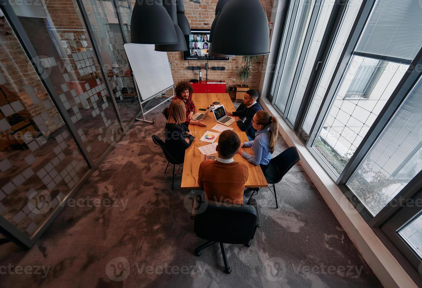 Top view of a modern startup office, a diverse team of business professionals engage in discussions on various projects and develop new business strategies, epitomizing creativity and innovation in photo