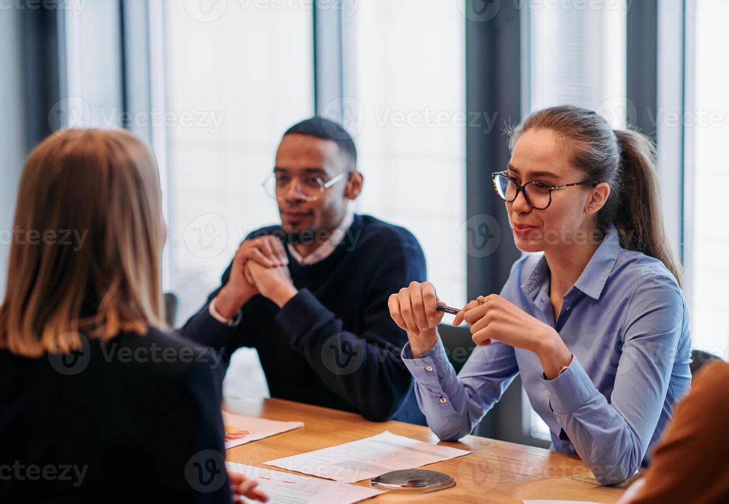 In the vibrant ambiance of a modern startup office, a diverse team of business professionals engage in discussions on various projects and develop new business strategies, epitomizing creativity and photo