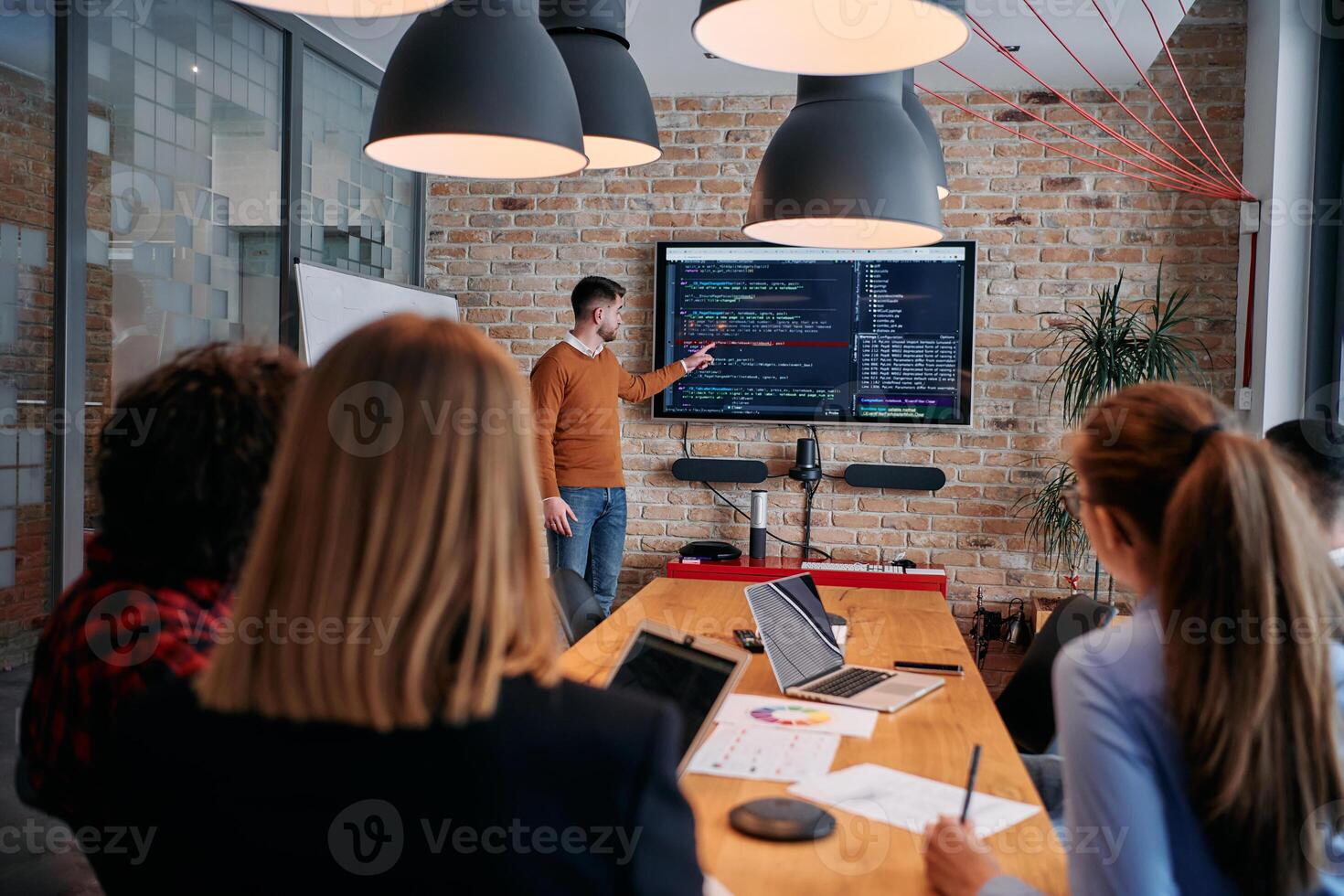 In a corporate setting businessman leads a meeting, passionately presenting a business plan to his attentive team, fostering collaboration and strategic thinking photo