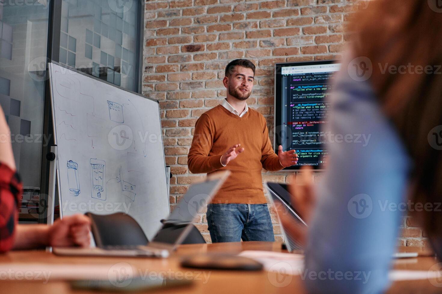 In a corporate setting businessman leads a meeting, passionately presenting a business plan to his attentive team, fostering collaboration and strategic thinking photo