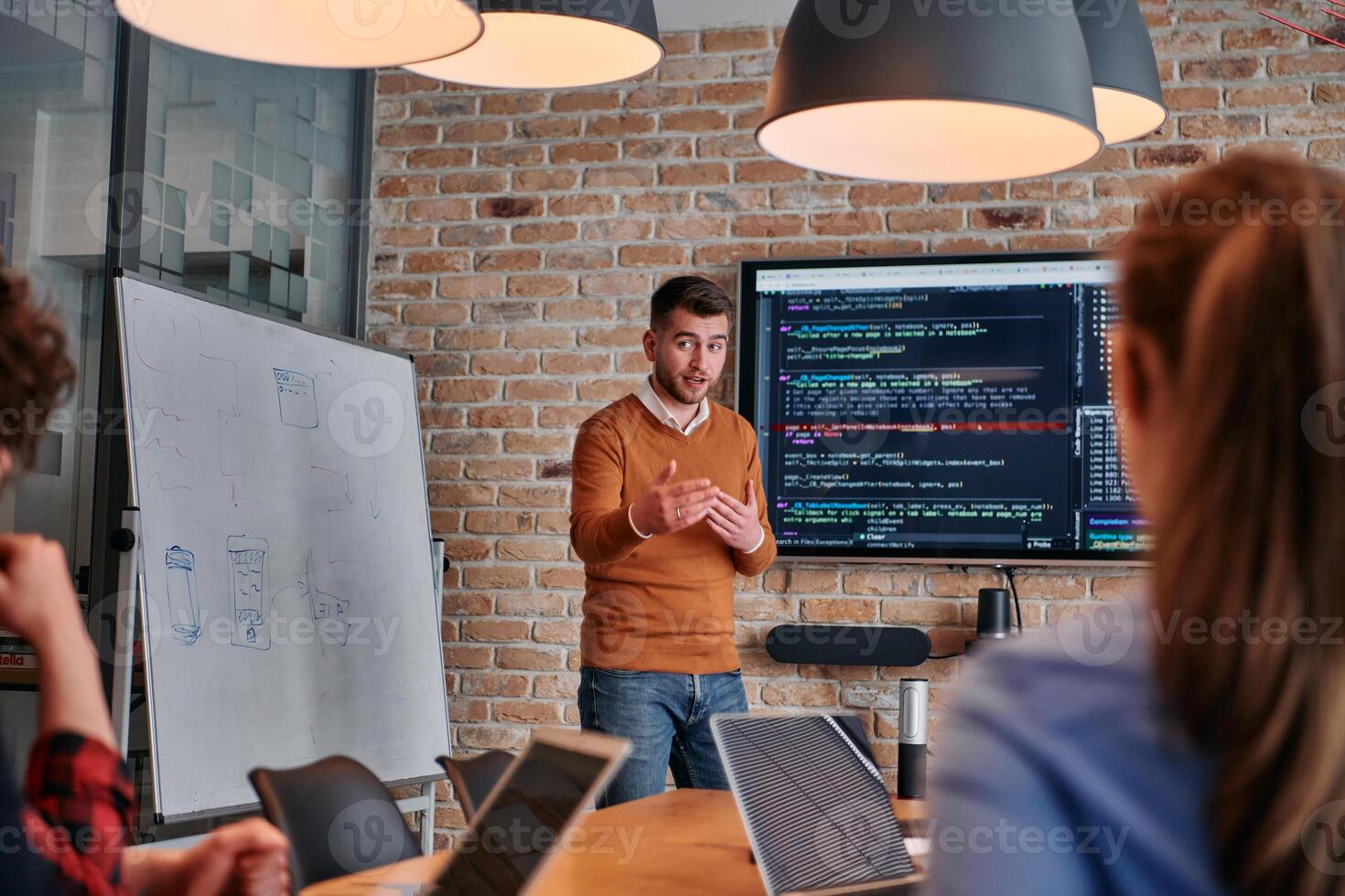 In a corporate setting businessman leads a meeting, passionately presenting a business plan to his attentive team, fostering collaboration and strategic thinking photo