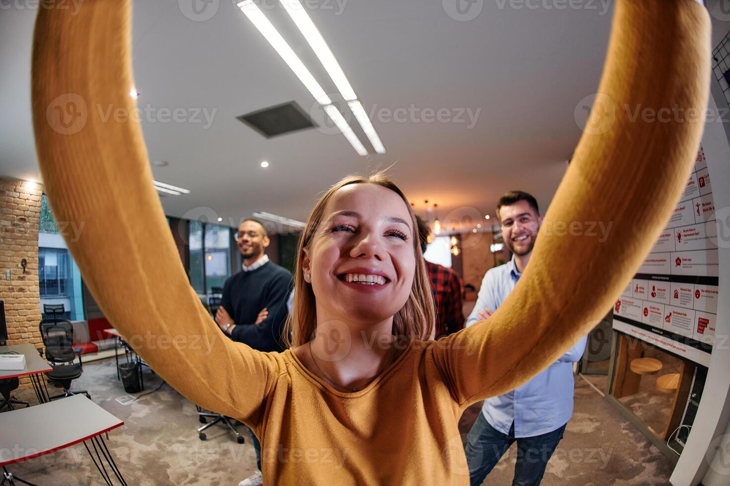 Wide-Angle Selfie of Business Blonde with Colleagues in Office photo