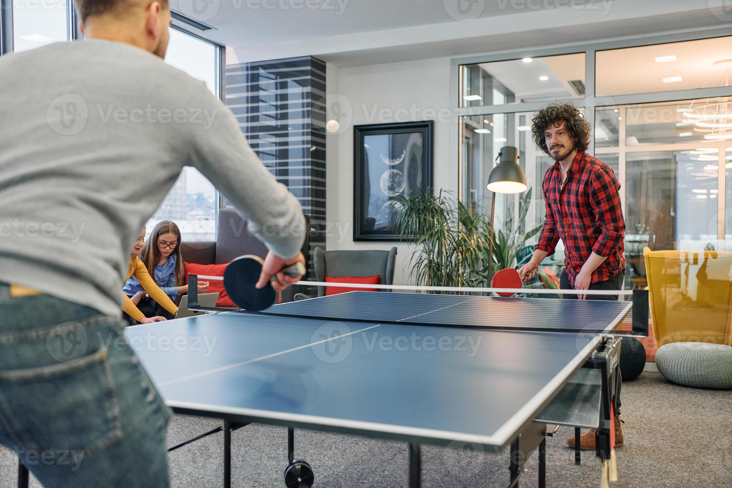 Business colleagues take a break from work to enjoy a game of table tennis fostering teamwork and camaraderie in the workplace 47919716 Stock Photo at Vecteezy