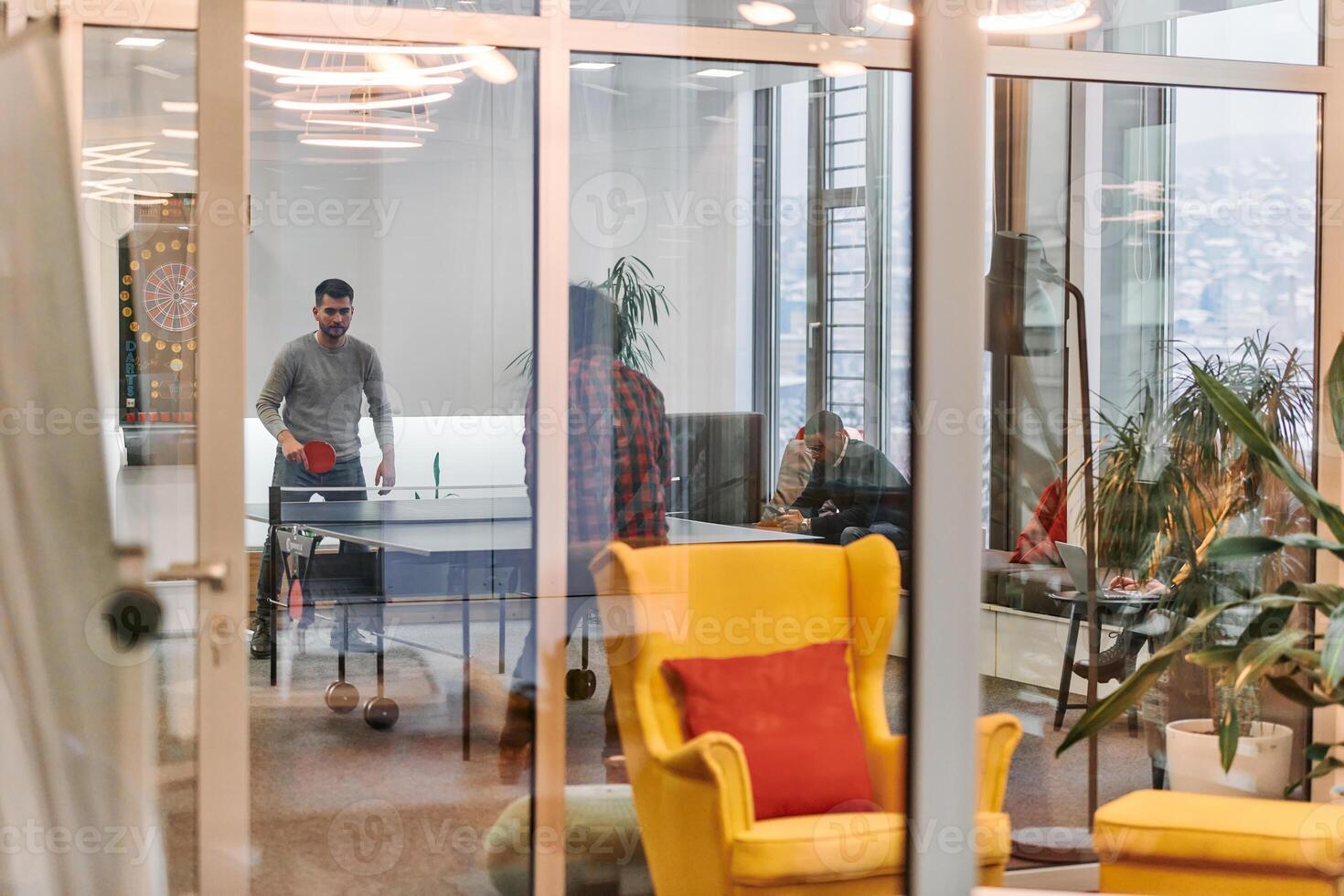 Business colleagues take a break from work to enjoy a game of table tennis, fostering teamwork and camaraderie in the workplace photo