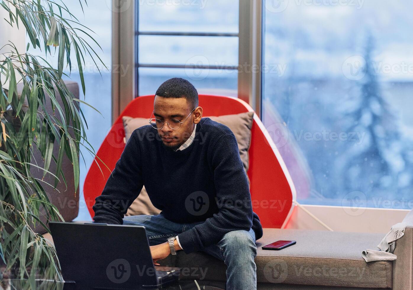 Overtime working. African American man with closed eyes is resting at work at laptop. Tired male programmer taking a break due to overtime work. photo