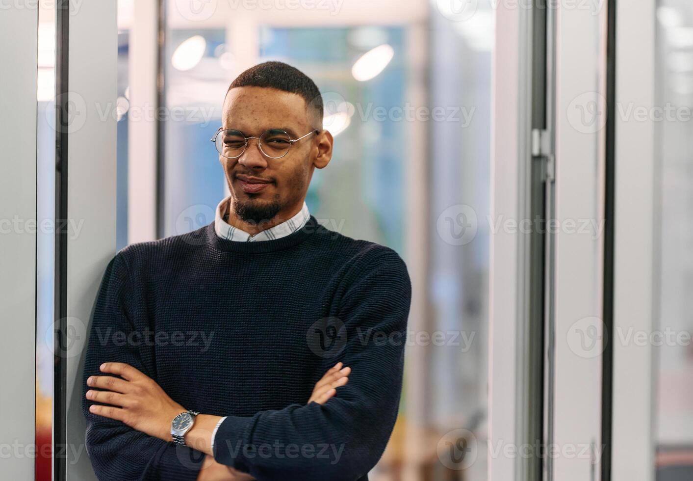 African-American Businessman Posing with Crossed Arms in Modern Office photo