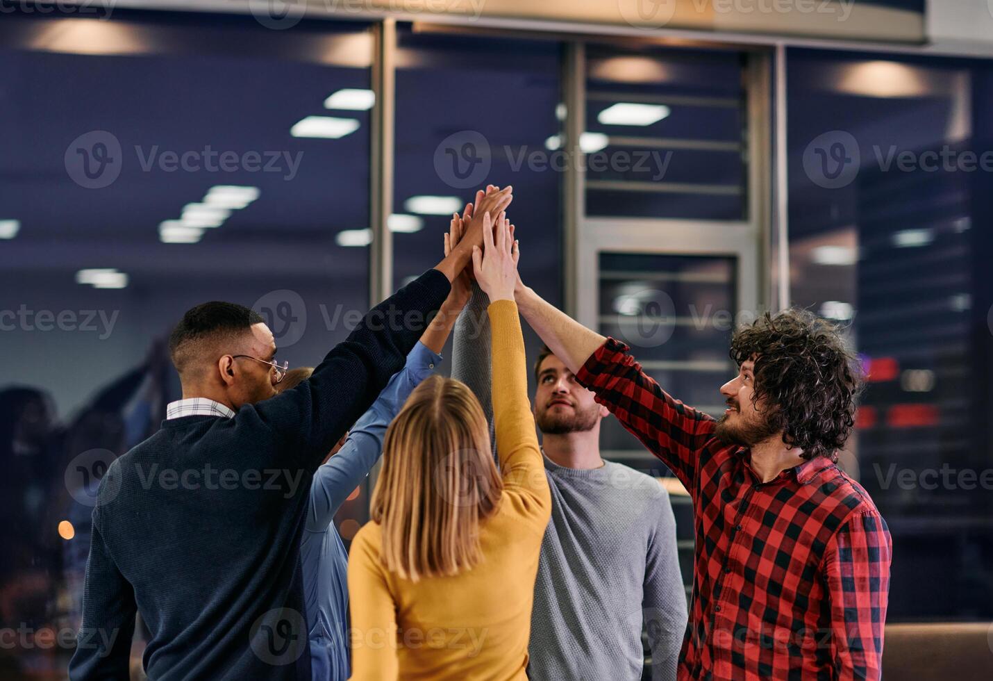 Overjoyed young multiethnic businesspeople have fun celebrate shared business success or victory in office. Smiling multiracial diverse employees feel excited win get good results. Teamwork concept photo