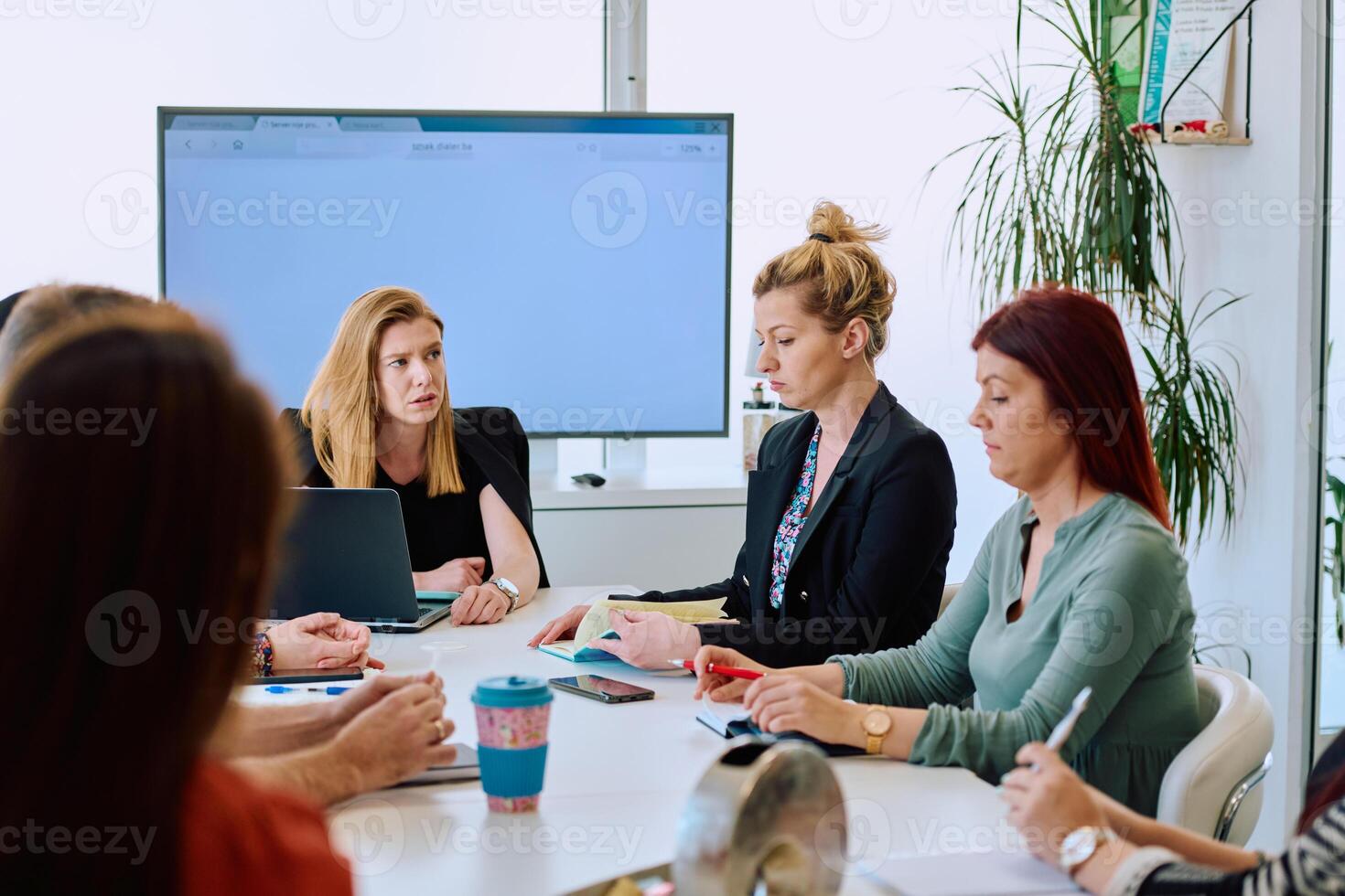 Diverse Business Team Discussing Projects in a Modern Glass Office. photo