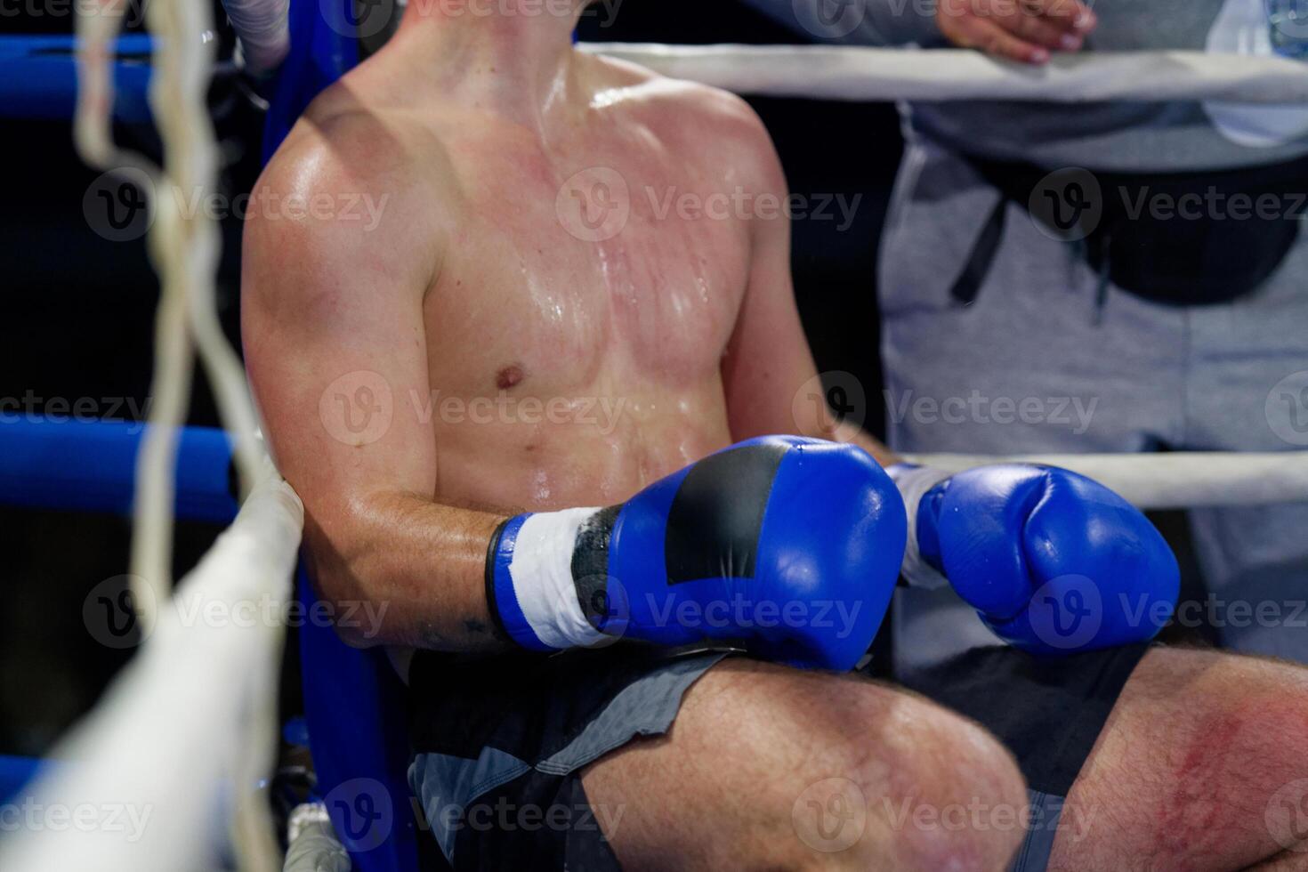 Cornered boxer receives strategic advice from trainer during intense bout. photo