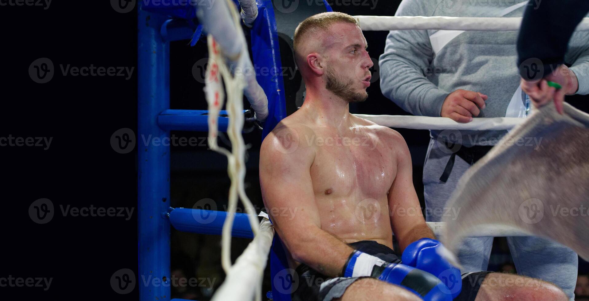 Cornered boxer receives strategic advice from trainer during intense bout. photo