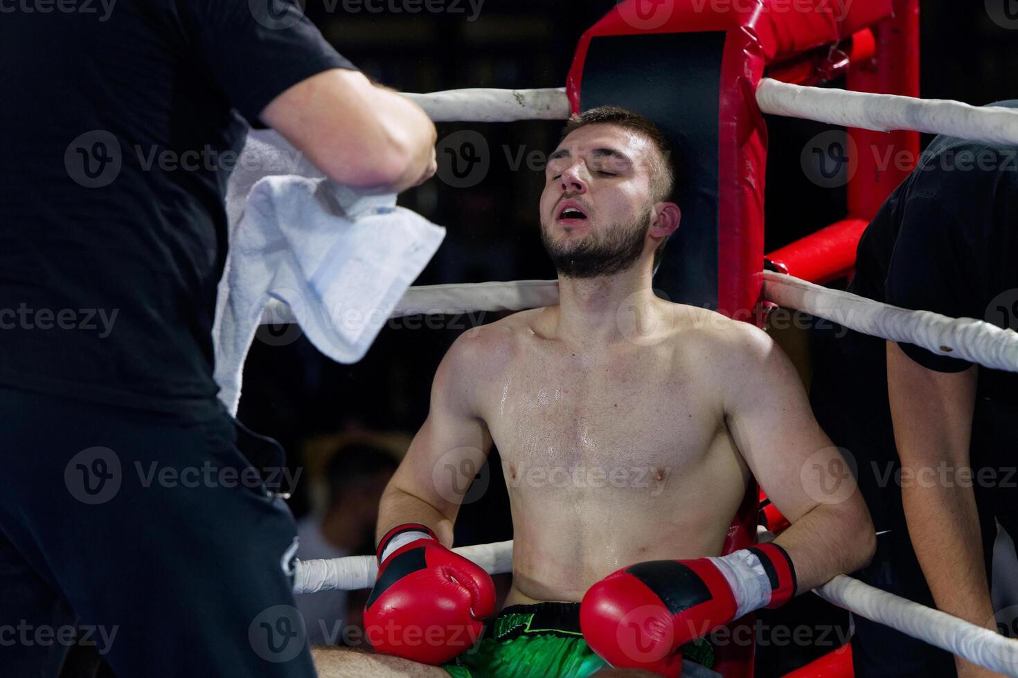 Cornered boxer receives strategic advice from trainer during intense bout. photo