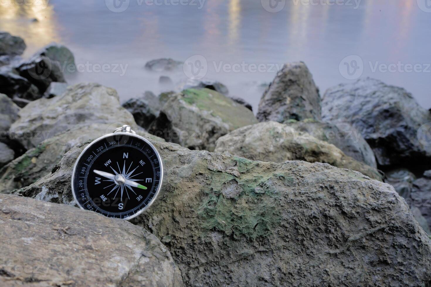 Finding success, vintage compass on the pile of stones. photo