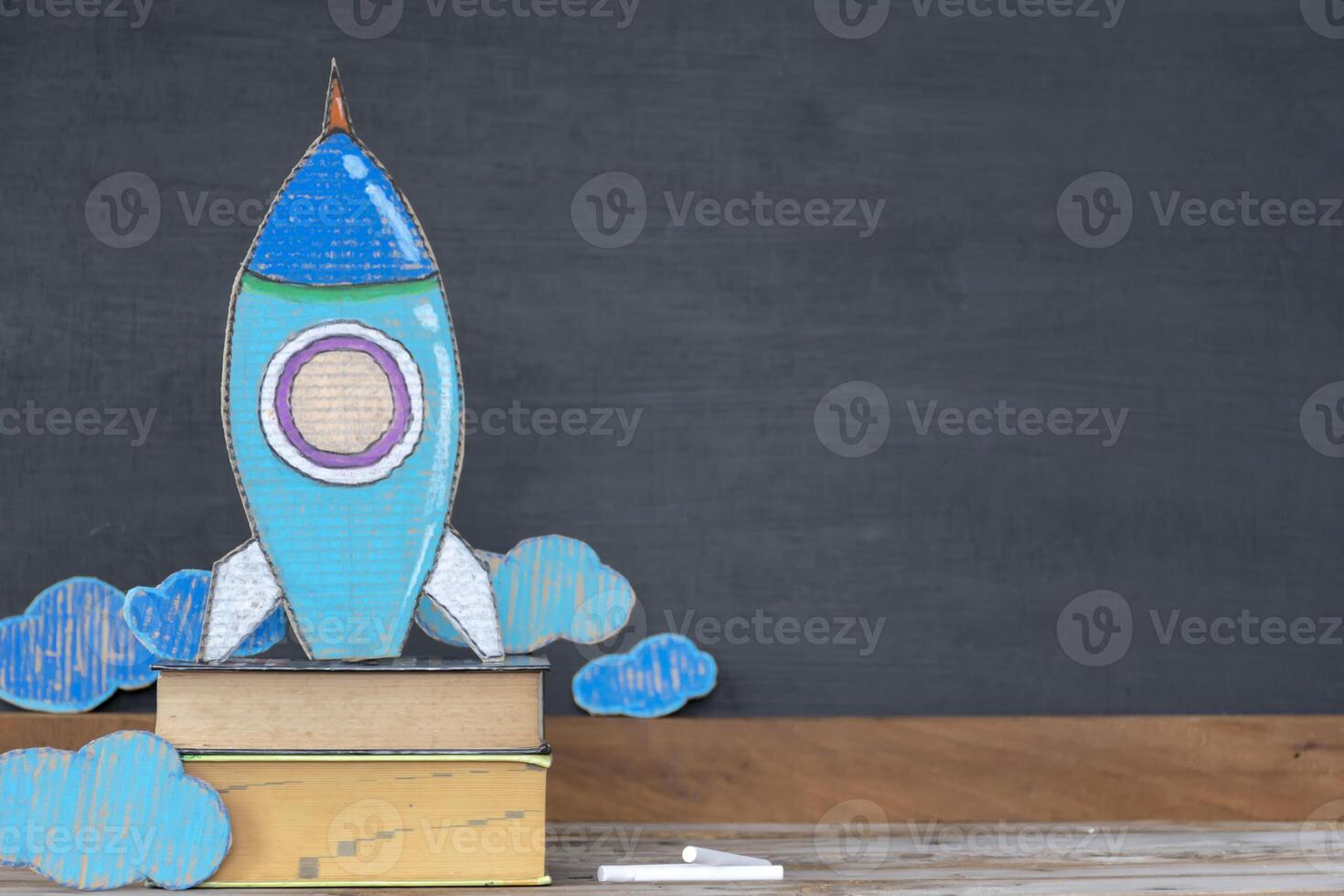 Back to school concept. Paper rockets are located on books. photo