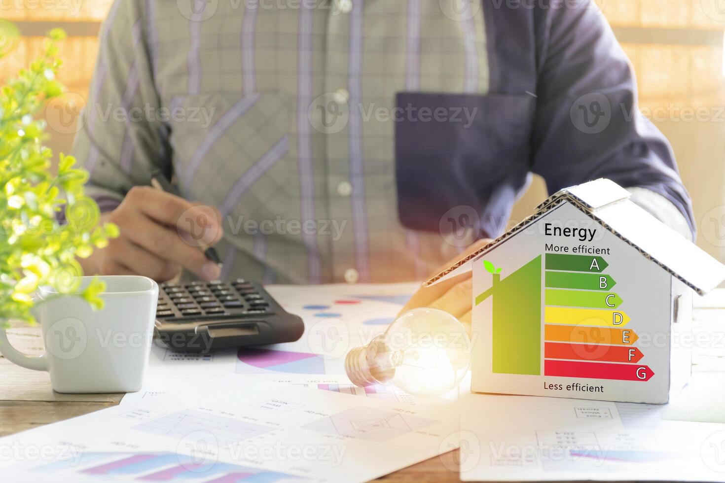 Men who are calculating cost savings from energy. Hand holding a pen. photo