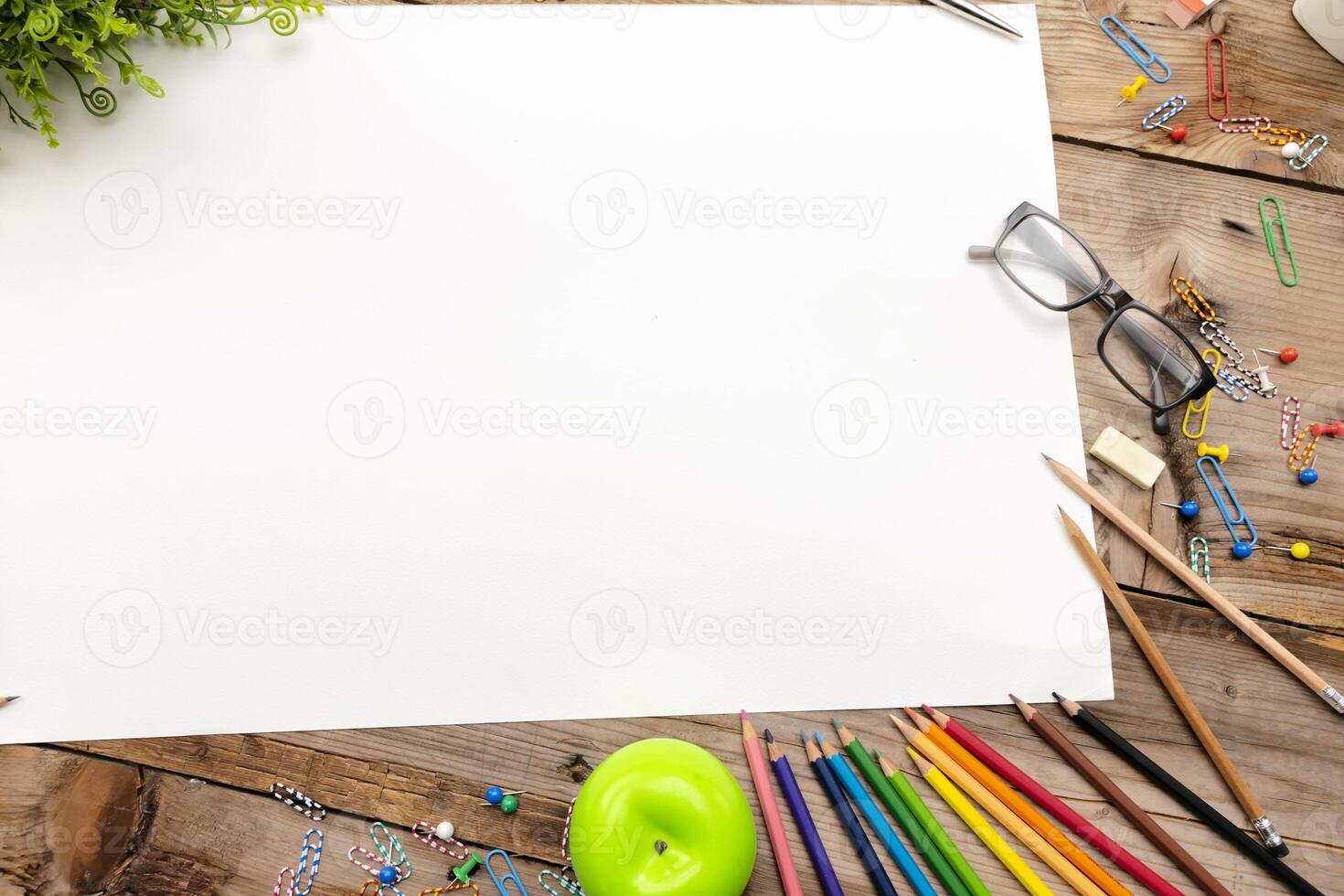 A desk with many stationery items placed,Large blank paper to put different content messages. photo