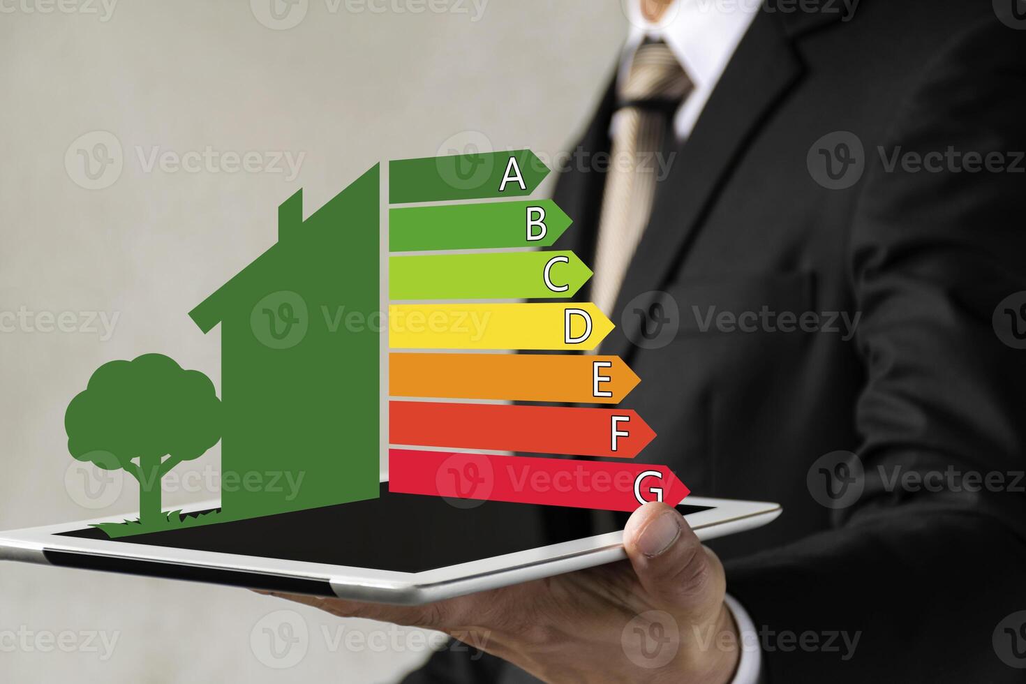 Businessman holding digital tablet and looking at house efficiency rating. photo
