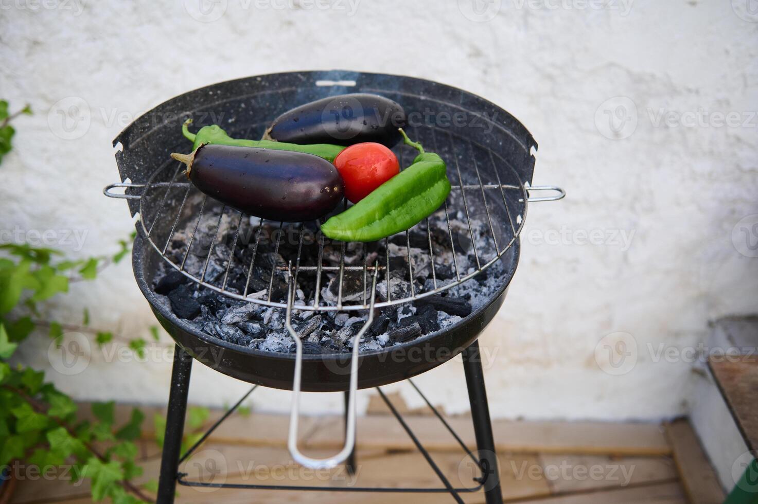 Fresh vegetables grilling on a charcoal barbecue outdoors photo
