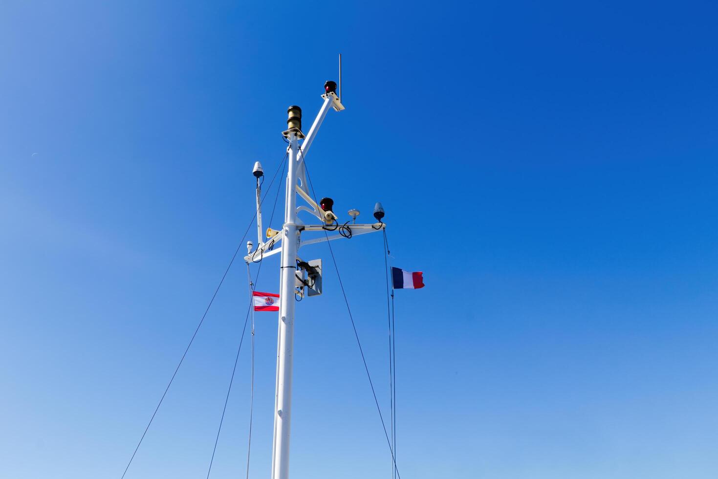 Papeete, French Polynesia, 2024 - Flags Of France Tricolor And French Polynesia Flying In Blue Sky photo