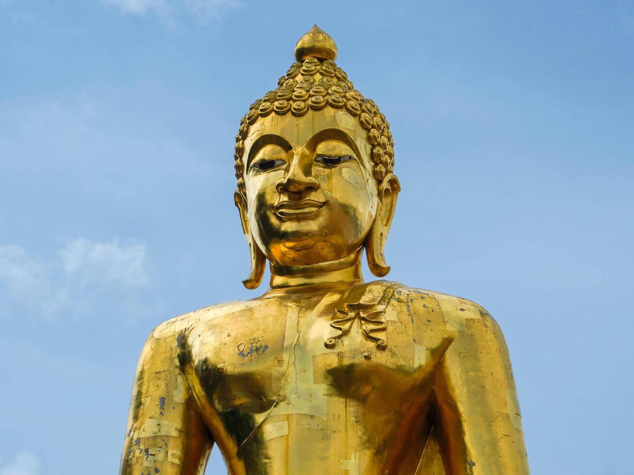 Big golden Buddha statue on a bright sky background - Landmark Famous sculpture statue in Thailand Temple. photo
