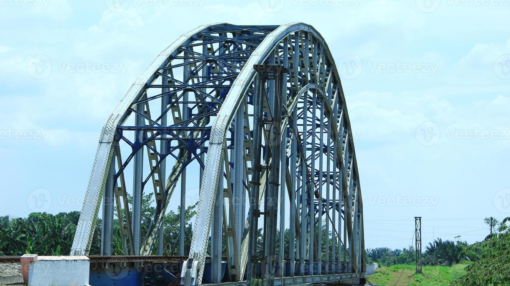 Railway tracks on a sturdy steel bridge visible on a beautiful day photo