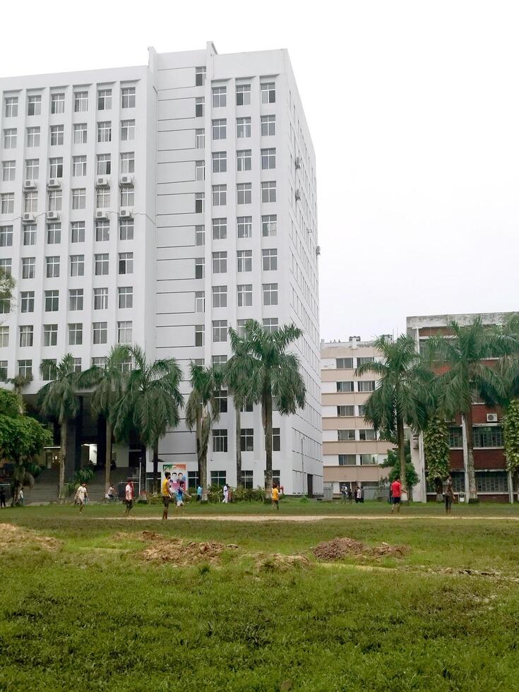 Landscape View of big trees and buildings next to green playground photo