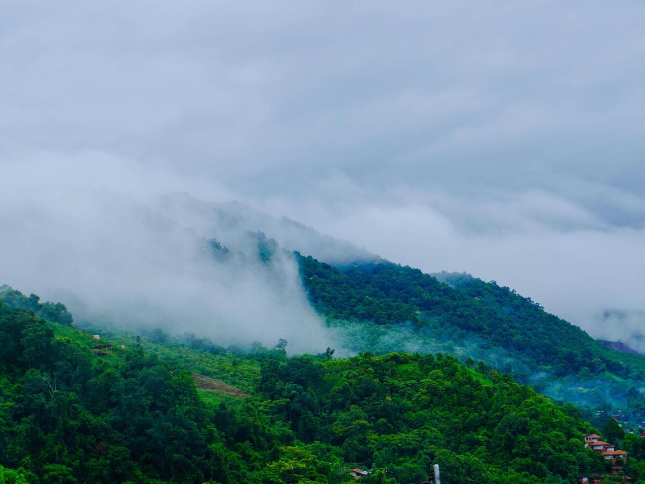 Aerial view of the beautiful Sapan village scenery, a small village in the middle of a valley surrounded by nature during the rainy season at Nan Province, Thailand. photo