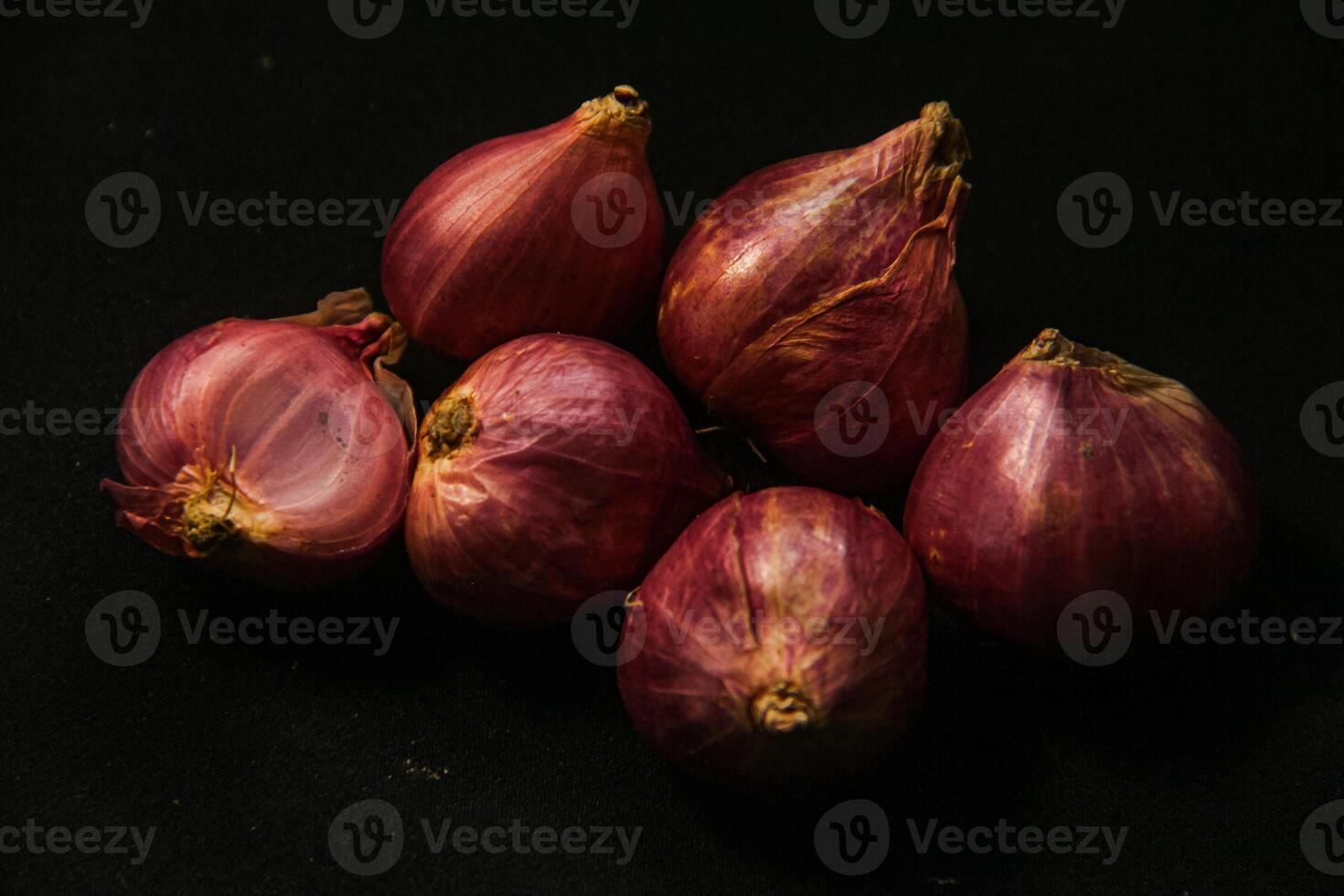 Close up of a whole red onion, isolated on a black background photo