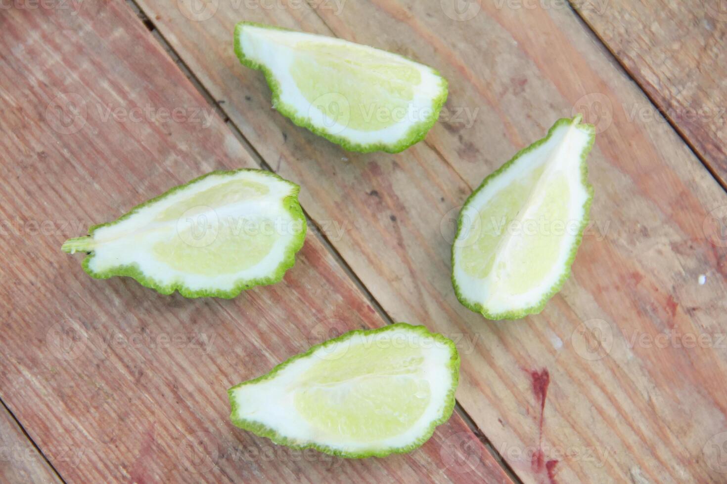 Fresh bergamot or sliced kaffir lime fruit with isolated on traditional wooden table photo