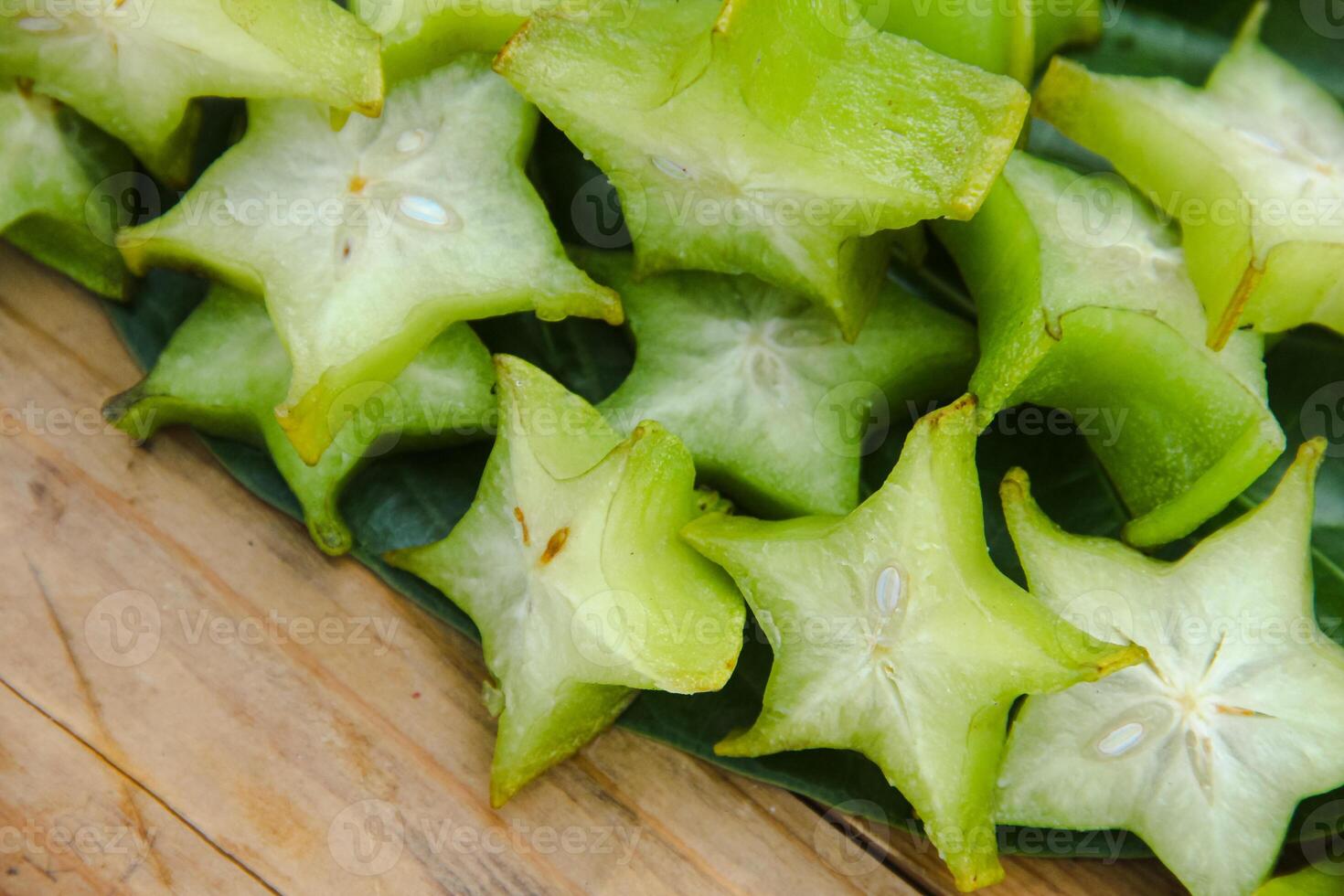 Carambola fruit with slice of star fruit on a wooden table photo